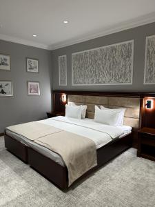 a bedroom with a large bed with white sheets at Mir Luxe Plaza in Tashkent