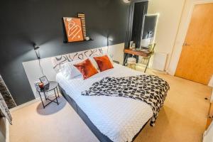 a bedroom with a large bed with orange and black pillows at Exquisite Living with BicoccaStays in Aberdeen