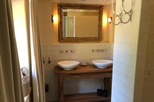 een badkamer met 2 witte wastafels en een spiegel bij Vakantiewoning Hof7tien90 in Nuth