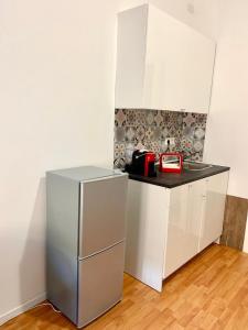 uma pequena cozinha com um frigorífico de aço inoxidável em The Tower centro em Sassari