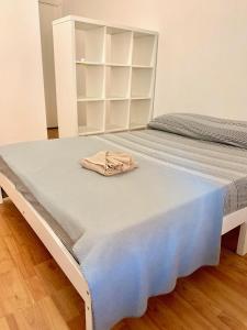 Una cama blanca con una toalla encima. en The Tower centro, en Sassari