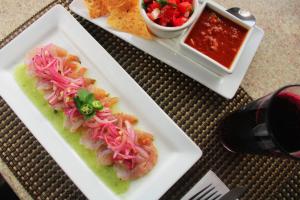 dos platos de comida con camarones y salsa en una mesa en Varali Grand Hotel en Mazatlán