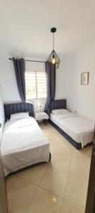 馬拉喀什的住宿－Les portes de Gueliz - apartment 6 people，一间卧室设有两张床和窗户。