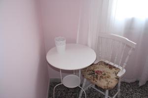 a white table and chair with a roll of paper on it at Hostal Isabel II in Figueres