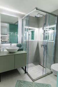 y baño con ducha acristalada y lavamanos. en Green and grey loft 2, en Alexandroupoli