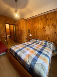 una camera con un letto in una stanza con pareti in legno di Casa da Roberto a Roccaraso