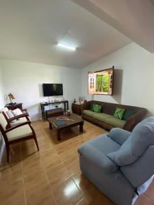 uma sala de estar com um sofá e uma mesa em Sítio Caminho das Acácias em São Lourenço da Mata