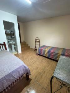 um quarto com uma cama, uma mesa e um banco em Sítio Caminho das Acácias em São Lourenço da Mata