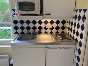 eine kleine Küche mit Spüle und Mikrowelle in der Unterkunft Studio cosy à 50m de la plage, Cabourg, 3 pers - FR-1-487-330 in Cabourg