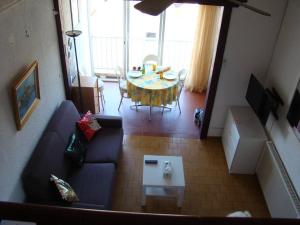 un salon avec une table et un canapé bleu dans l'établissement Le Bellevue YourHostHelper, à Gruissan