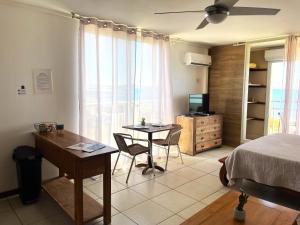 a bedroom with a bed and a table and a desk at Studio Marigot, Vue Panoramique in Saint Martin
