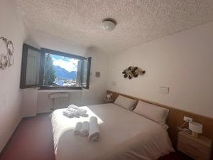 a bedroom with a bed with towels on it at Delizioso appartamento nelle Dolomiti in Madonna di Campiglio