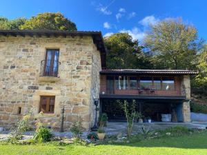 a large stone building with a balcony on the side at El Portalón de Luena - Casa Rural in Tablado