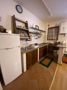 a kitchen with a white refrigerator and a sink at Casa da Roberto in Roccaraso