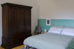 a bedroom with a large bed and a wooden cabinet at M&B apartments in Rome