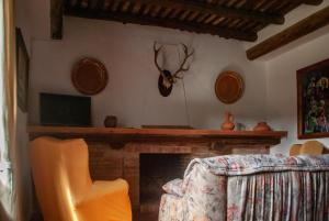 a living room with a fireplace with antlers on the wall at Cortijo San Rafael in Constantina