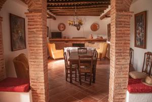cocina y comedor con mesa y sillas en Cortijo San Rafael, en Constantina