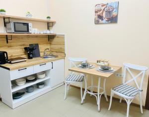 a small kitchen with a table and two chairs at Like Home Rooms in Almaty