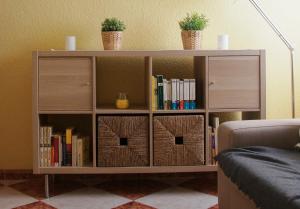 a book shelf with books and plants on it at Piso acogedor a 50m de la playa in Almería