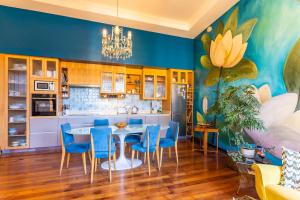 a kitchen with a dining table and blue chairs at Val Paradou - ex - Casa Magnolia in Valparaíso