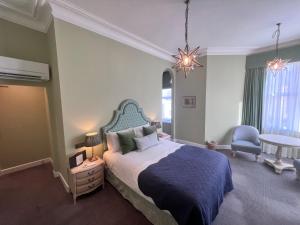 Best Western Plus The Connaught Hotel and Spa في بورنموث: غرفة نوم بسرير وطاولة وكرسي