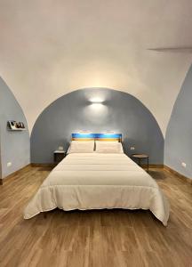 1 dormitorio con 1 cama grande, paredes azules y suelo de madera. en Nel Vico, en Nápoles