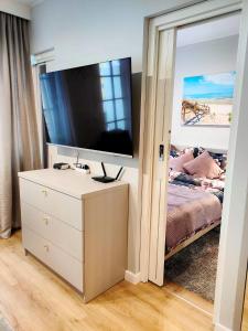 a bedroom with a dresser with a tv on top at Apartament MajGraj sąsiedztwo Parku Zdrojowego in Świnoujście