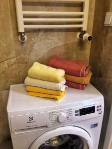 uma pilha de toalhas em cima de uma máquina de lavar roupa em Apartament MajGraj sąsiedztwo Parku Zdrojowego em Świnoujście