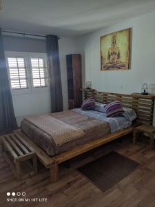 1 dormitorio con 1 cama grande con marco de madera en The Sunset, en Betancuria