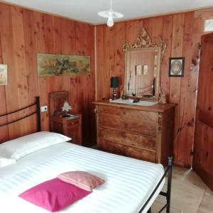 sypialnia z łóżkiem, komodą i lustrem w obiekcie Residenza Le Fontane w mieście Ceppo Morelli