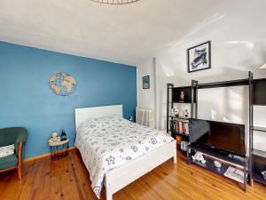 ein Schlafzimmer mit einem weißen Bett und einer blauen Wand in der Unterkunft Appartement Granville, 2 pièces, 2 personnes - FR-1-361-428 in Granville