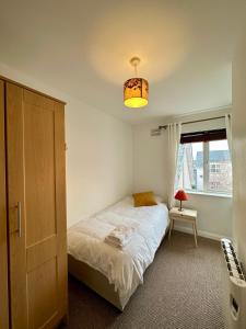 a small bedroom with a bed and a light at Stunning City Centre Apartments in Waterford