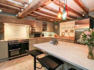 a kitchen with a large kitchen island with two stools at Pentre Hall in Oswestry