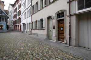 a cobblestone street with a building and a wooden door at Hotel Münzgasse - Self Check-in in Luzern