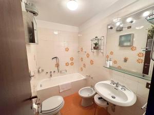 uma casa de banho com um lavatório, um WC e uma banheira em Delizioso appartamento nelle Dolomiti em Madonna di Campiglio