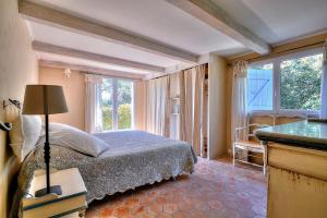 a bedroom with a bed and a large window at Villa Provençale avec 2 maisons d'amis ,piscine ,Jacuzzi ,vue mer in La Roquette-sur-Siagne