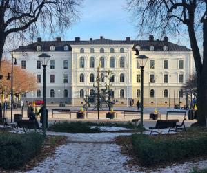 a large white building with benches in front of it at Vänerport Stadshotell i Mariestad in Mariestad
