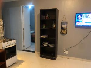 uma sala de estar com uma televisão e uma cozinha em Casinha Vilarejo em Cabo Frio