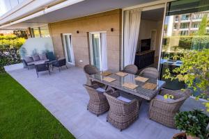 a patio with a table and wicker chairs at GINVA - Costa Ballena & Eleven Views in Costa Ballena