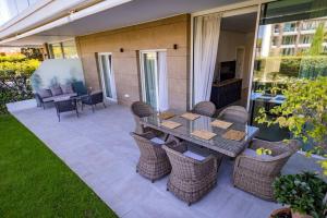 un patio con una mesa y sillas de mimbre en GINVA - Costa Ballena & Eleven Views, en Costa Ballena