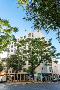 a white building with a tree in front of it at Spacious & Sunny Flat - Loulé in Loulé