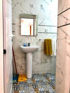 a bathroom with a sink and a mirror at Padova Surf House in Imsouane