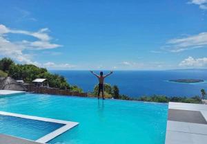 a man standing on the edge of a swimming pool at SCIA Hills Exclusive 25pax WiFi Netflix HBO Videoke Pool in Oslob