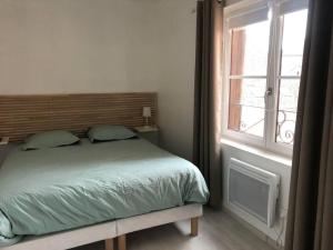 sypialnia z łóżkiem i oknem w obiekcie 15 personnes Chez Delphine et Guillaume w mieście Montbard
