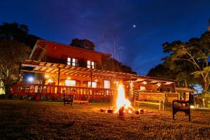 a fire pit in front of a house at night at Hotel Fazenda Morros Verdes Ecolodge in Ibiúna