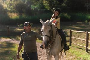 a man and a girl riding on a horse at Hotel Fazenda Morros Verdes Ecolodge in Ibiúna