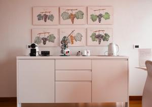 a white cabinet in a room with pictures on the wall at Casa Gallinotto in Alba