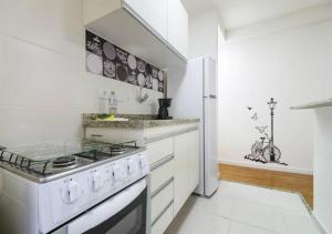 cocina blanca con fogones y nevera en Quality Place Apartments by BnbHost, en São Paulo