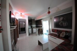 cocina y sala de estar con TV grande en la pared en Pousada Marias do Mar, en Bombinhas