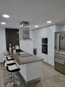 a kitchen with white cabinets and stainless steel appliances at Mikaela Guest House 2 in Ramada